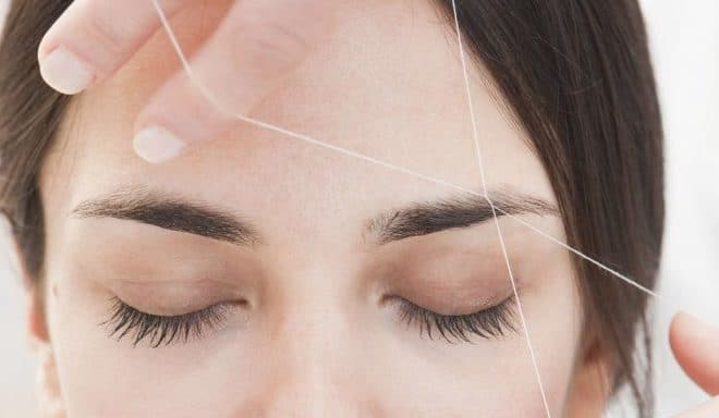 person getting their eyebrows threaded