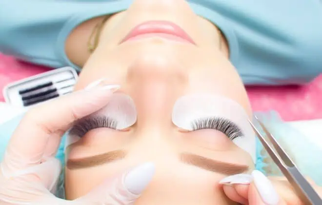 A professional applying a lash lift treatment to a client's natural lashes